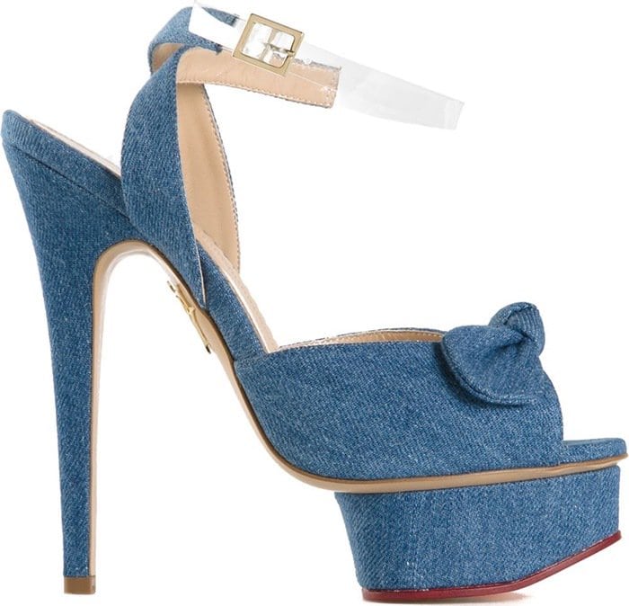 Charlotte Olympia’s “Serena” sandals elevate denim to couture status with their sky-high stiletto heel, curved platform, and signature knot detail