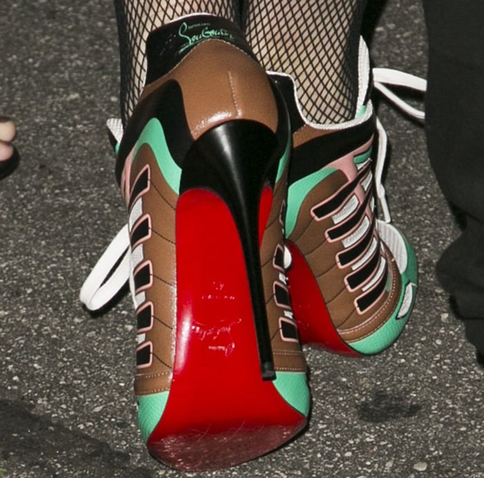 Gwen Stefani adds height and edge with her striking Christian Louboutin heels, featuring bold red soles and a colorful, athletic-inspired design
