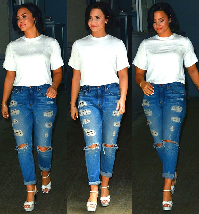 Demi Lovato stepped out in a crisp white tee and distressed cuffed jeans, adding dramatic lift to the laid-back look with towering white Saint Laurent “Bianca” platform sandals