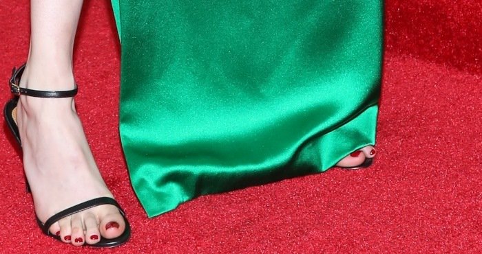 Emma Roberts' bold red pedicure contrasts against her delicate black ankle-strap sandals