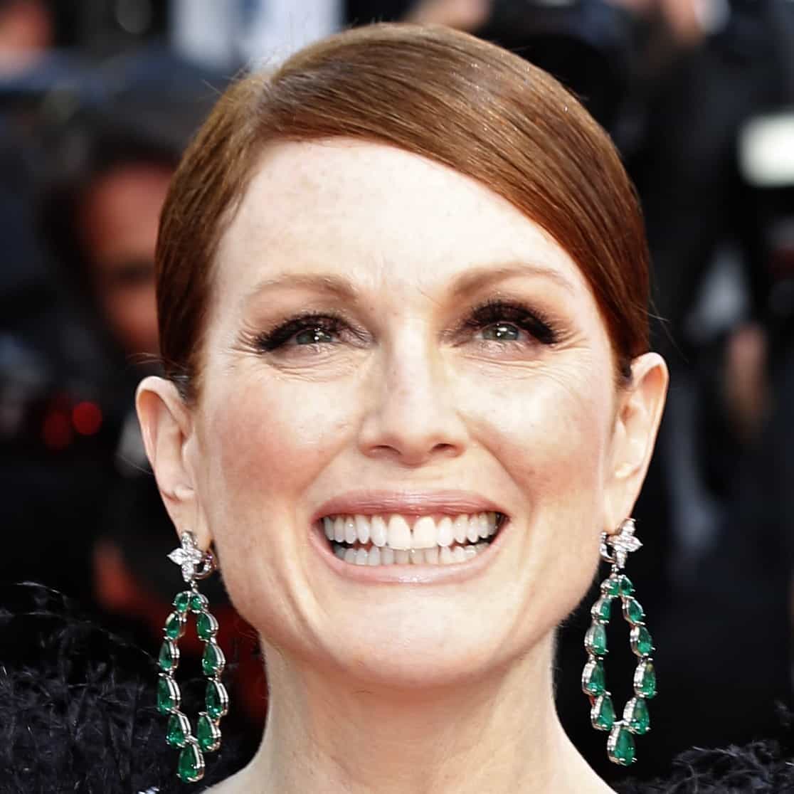 Julianne Moore radiated elegance in striking emerald Chopard drop earrings, each set with cascading green gemstones that framed her face and added vibrant contrast to her sleek red-carpet beauty look