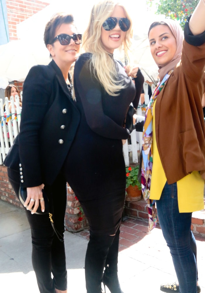 Khloé Kardashian rocking sunglasses from Porsche while taking a photo with a fan