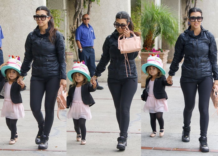 Kourtney Kardashian’s daughter Penelope looks adorable in a pale pink ballet dress layered with a black blazer, black tights, and blush ballet flats, finishing the look with a playful birthday cake–themed hat