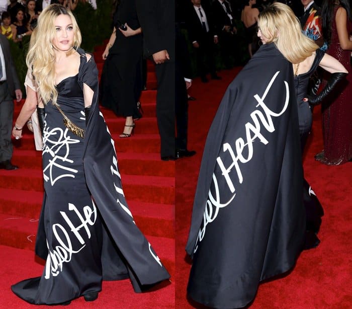 Madonna stands out in a custom Moschino gown and matching cape, both emblazoned with "Rebel Heart" in bold script, complemented by black gloves at the 2015 Met Gala