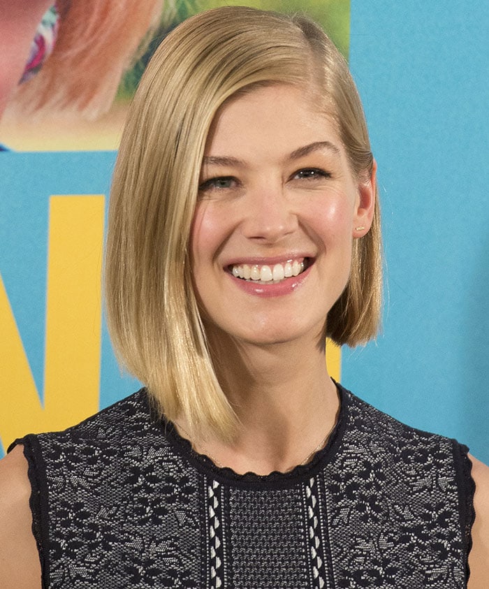 Rosamund Pike wears her sleek side-parted blonde bob straight, keeping the beauty look understated against her intricately textured Alexander McQueen dress