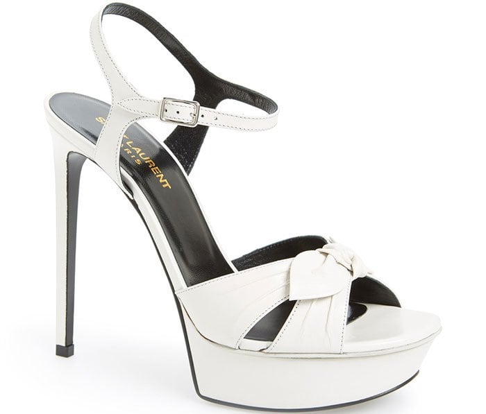 The Saint Laurent “Bianca” in pearl leather showcases its signature knotted vamp, sculpted platform, and razor-sharp stiletto for a striking 1970s-inspired finish