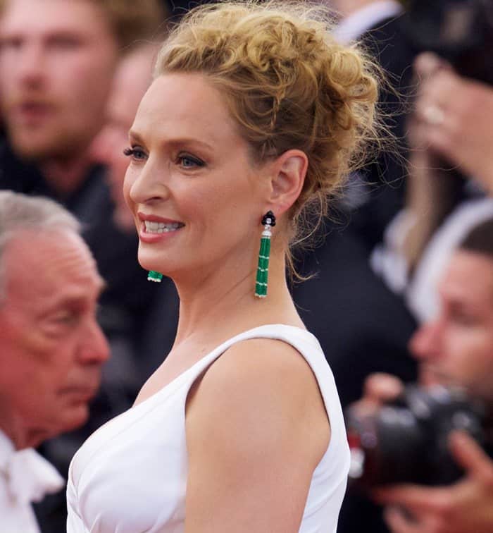 Uma Thurman stuns with elegant emerald drop earrings and a sophisticated updo at the 2015 Met Gala