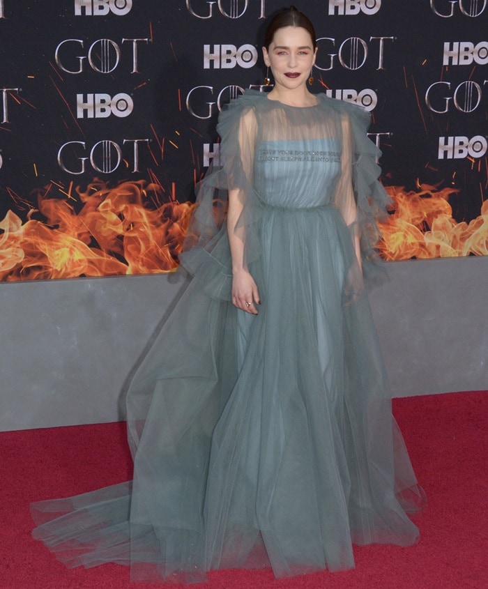 Emilia Clarke brings ethereal volume to the Game of Thrones Season 8 premiere in a misty Valentino tulle gown, grounded by Christian Louboutin “Cross Me” sandals whose delicate straps and lift subtly lengthen her frame beneath the sweeping layers