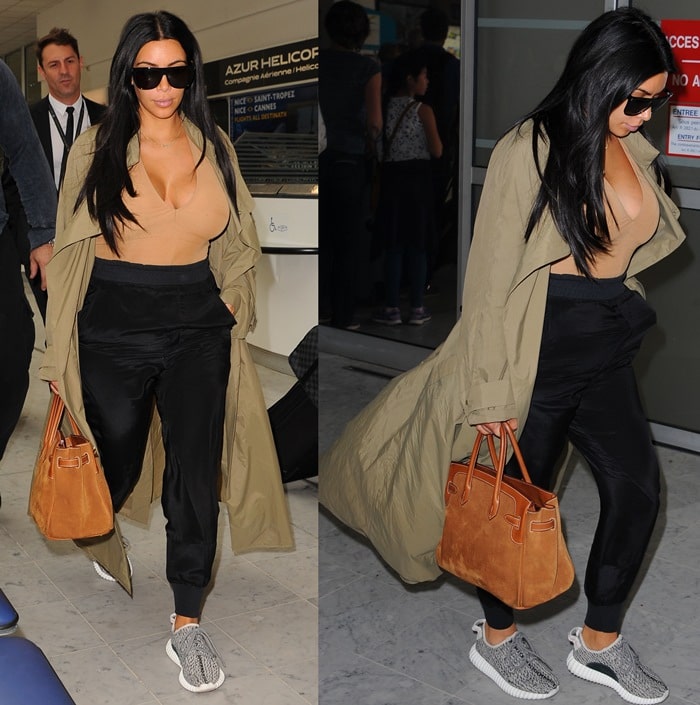 Kim wore neutral tones for her airport stroll, opting for Haider Ackermann jogging bottoms, a suede Hermès bag, an olive duster jacket, and a pair of "Yeezy 350 Boost" sneakers