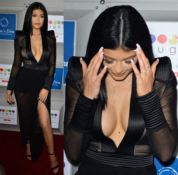 Kylie Jenner turns heads in a revealing black ensemble with a plunging neckline and sheer details, featuring padded shoulders for an edgy look at the Sugar Factory Grand Opening in Miami Beach