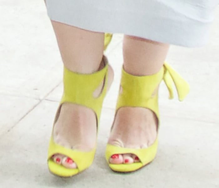 The sculptural ankle-cutout design and delicate back-tie detail gave her lemon-hued suede heels a feminine yet architectural finish