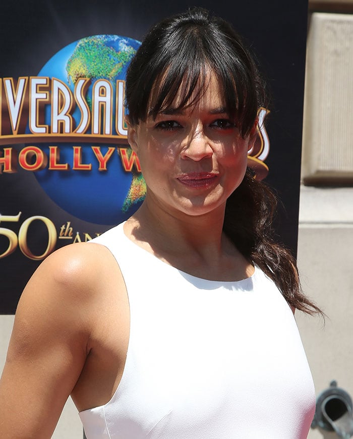 Michelle Rodriguez keeps it simple and elegant with her wavy hair tied back into a low ponytail, complemented by natural-looking makeup and a touch of rose-colored lipstick