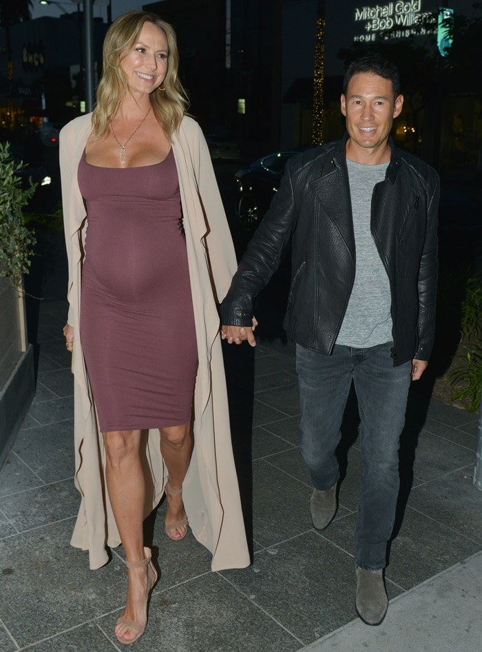 Stacy Keibler showcased her baby bump in a mauve bodycon dress, a flowing cream duster, and nude ankle-strap sandals while stepping out for dinner with husband Jared Pobre