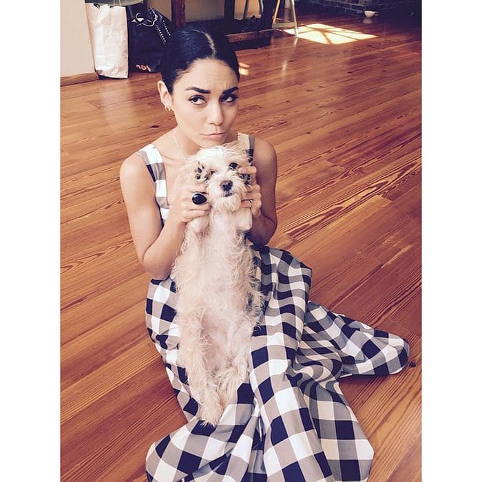 Vanessa poses for a photo with her pup while wearing her Dolce Gabbana gingham dress