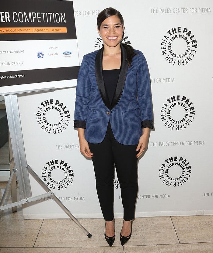 She wore a blue pinstriped tuxedo jacket with black satin lapels over slim trousers and a black top, balancing professionalism with red-carpet polish