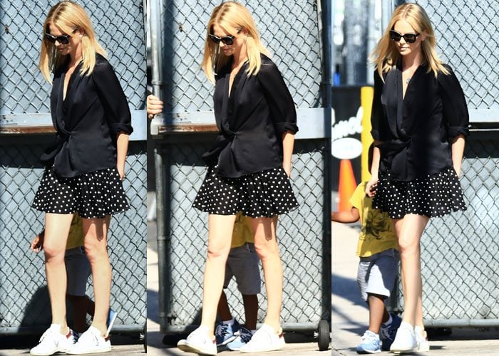 Charlize Theron is shown wearing a black blouse, a short polka-dotted swing skirt, and her Isabel Marant Bart sneakers