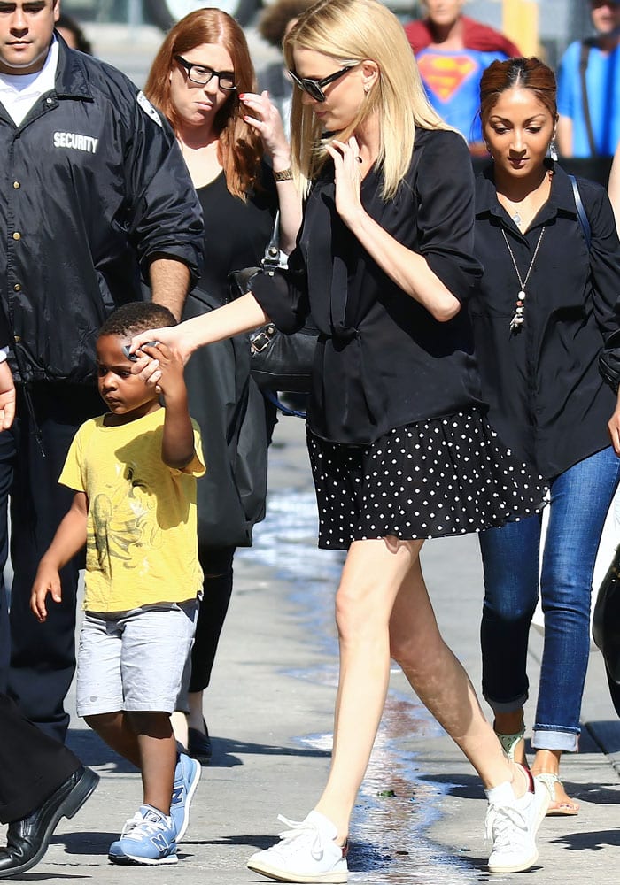 Charlize Theron, in a black blouse and polka-dotted skirt, arrives at the ABC studios with her son Jackson for Jimmy Kimmel Live! in Los Angeles on July 21, 2015