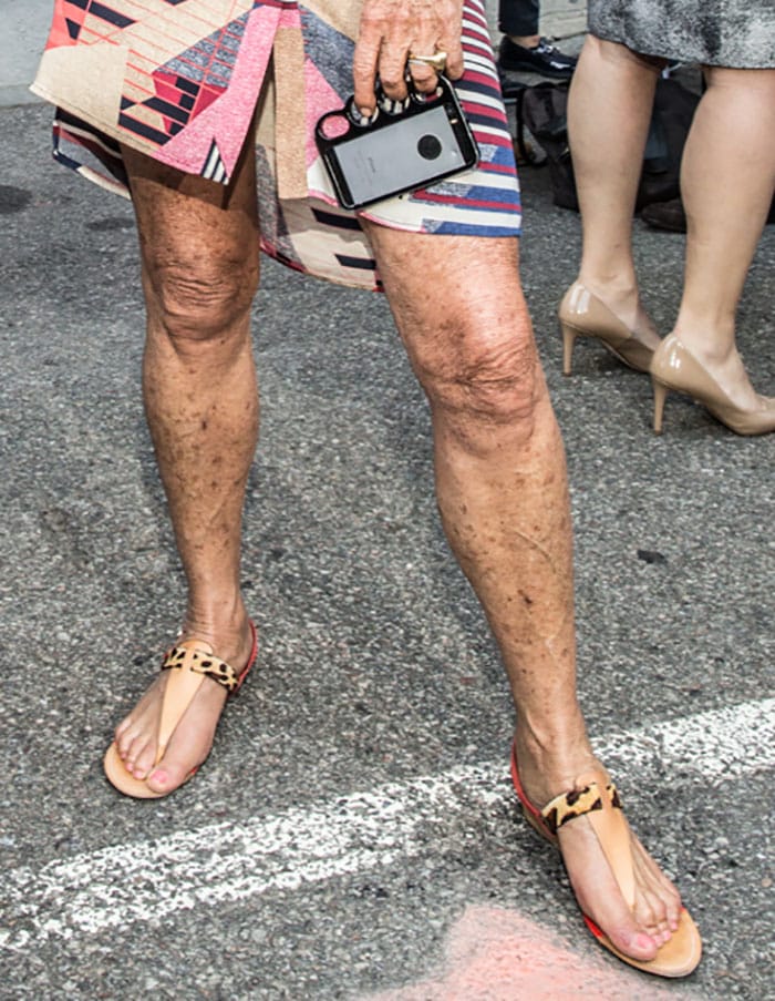 A close-up highlights Diane von Fürstenberg’s practical yet playful T-strap sandals, featuring leopard-print accents and tan leather details designed for all-day comfort