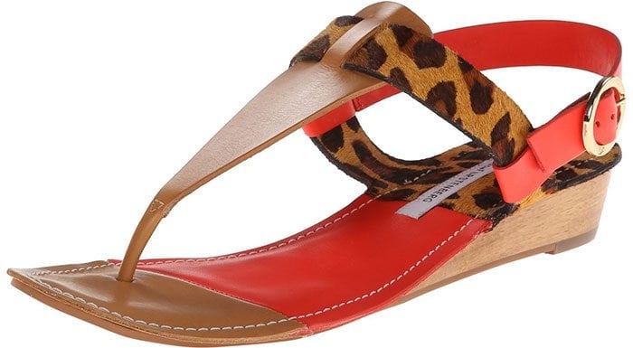 The DVF “Darling” sandal in leopard haircalf pairs warm tan leather and bold tangerine accents with a low, walkable wedge designed for effortless summer wear