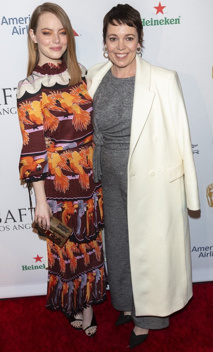 Emma Stone joined her The Favourite co-star Olivia Colman at the BAFTA Tea Party at the Four Seasons Hotel in Beverly Hills on January 5, 2019, wearing a vibrant bird-print Fendi Spring 2019 dress styled with black Givenchy sandals and a metallic Louis Vuitton clutch, while Colman contrasted the bold look in a relaxed gray jumpsuit layered beneath an elegant ivory coat