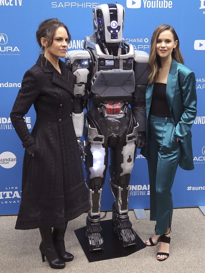 Clara Rugaard paired her teal satin suit with strappy black heels, while Hilary Swank styled her black trench coat with sleek platform ankle boots at the I Am Mother Sundance premiere