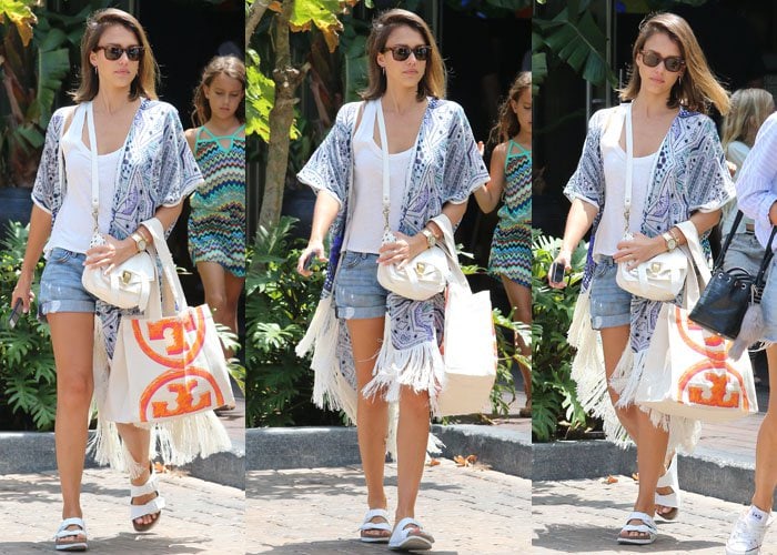 Jessica Alba in casual denim shorts from Fidelity paired with a white tee and a fringed cardigan from Athena Procoupio