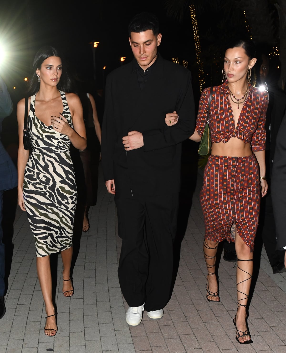 Kendall Jenner balances a zebra-print slip dress with minimalist black sandals, while Bella Hadid sharpens her patterned co-ord with lace-up stiletto heels as they step out with Fai Khadra for a Shabbat dinner in Miami