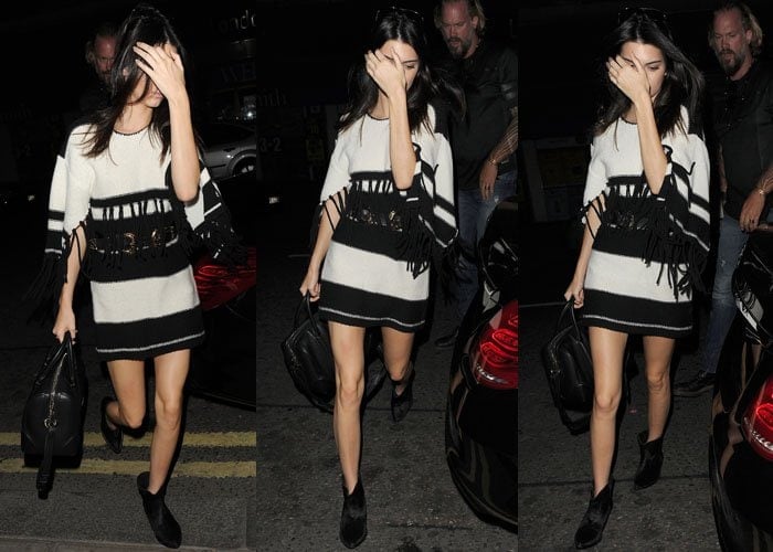 Kendall Jenner steps out at night in a black-and-white fringed mini dress, finishing the look with sleek black ankle boots and a structured leather bag