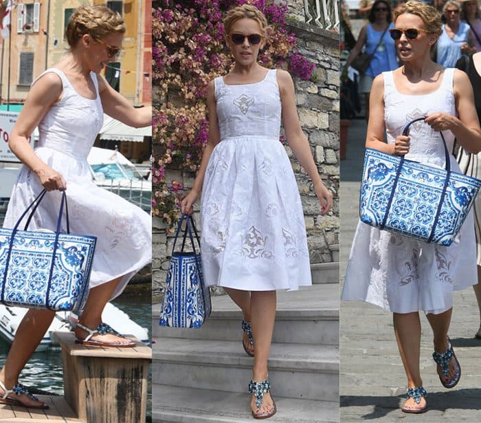 Kylie Minogue perfectly pairs a white sundress with a blue and white printed Dolce Gabbana bag and embellished flat sandals, embodying effortless resort chic in Portofino, Italy, on July 13, 2015