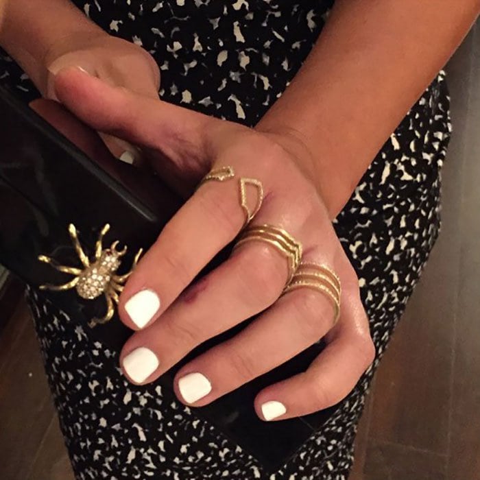 Michele’s accessories come into focus as she holds a Charlotte Olympia box clutch, her EF Collection rings adding a subtle sparkle to the ensemble