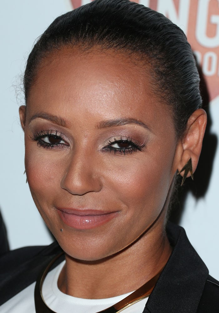 Mel B shows off her hazel eyes with fluttery lashes and complements her look with geometric gold earrings and a sleek, modern necklace