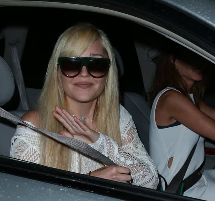 Amanda Bynes styled her look with sleek, straight platinum blonde hair, oversized square sunglasses, and minimal accessories, letting her white lace off-the-shoulder mini dress take center stage