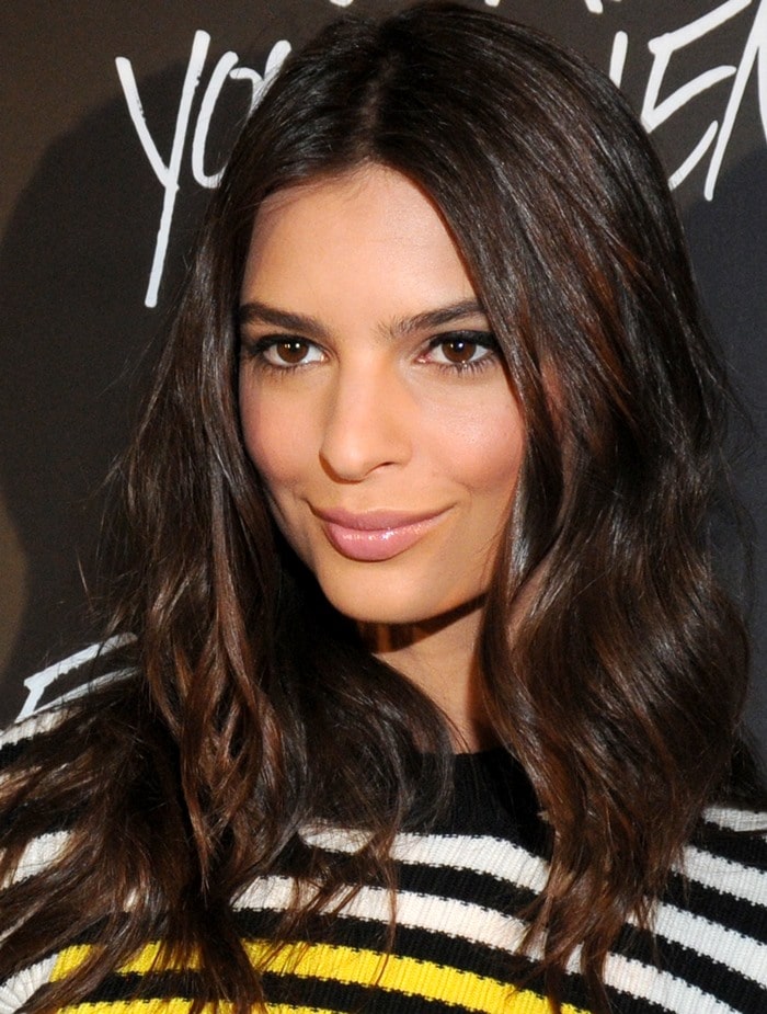 Emily Ratajkowski frames her look with soft, glossy waves and a striped cropped knit, balancing bold pattern with a polished, skin-baring silhouette