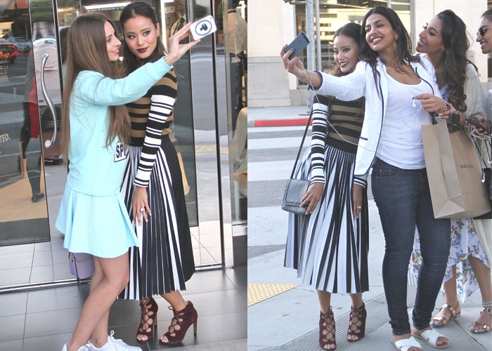 Stopping for selfies with fans, Jamie’s look holds its impact from every angle—her wine-toned heels anchoring the graphic stripes with a warm, polished finish