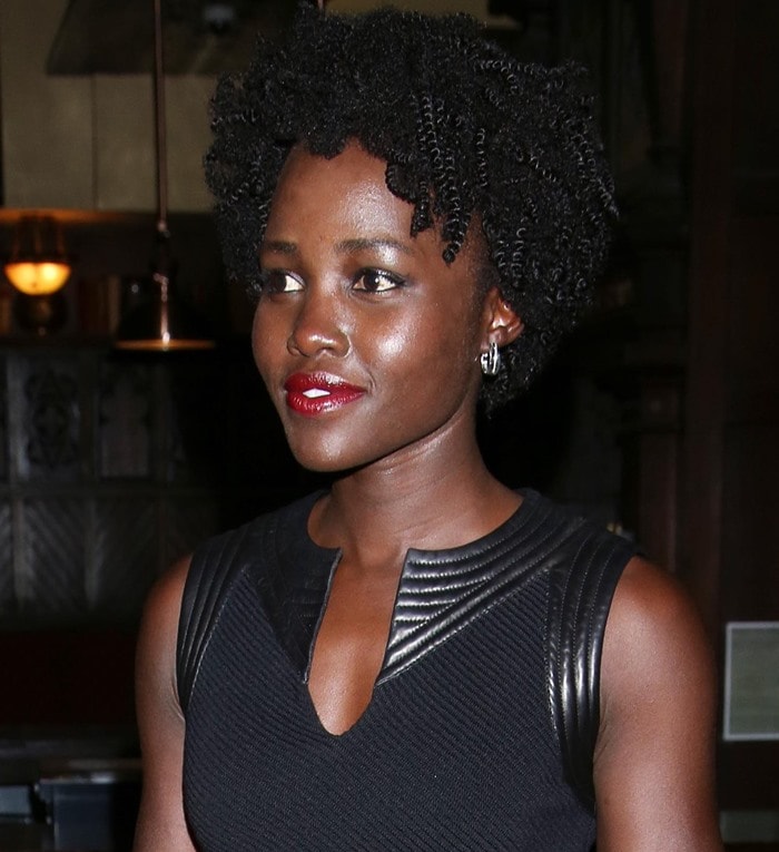 Lupita Nyong'o looks effortlessly chic with her natural curls, a bold red lip, and minimal jewelry