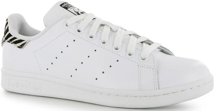 The Adidas x Raf Simons Stan Smith reimagines the classic tennis shoe with premium leather, a perforated “R” logo, and zebra-patterned pony hair detailing on the heel tab