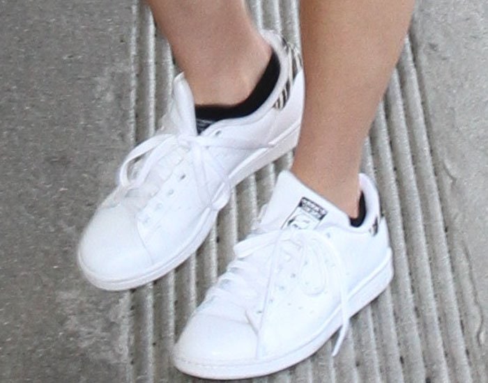 Bella Thorne keeps her airport look casual with Adidas x Raf Simons Stan Smith sneakers featuring the collaboration’s signature perforated “R” branding