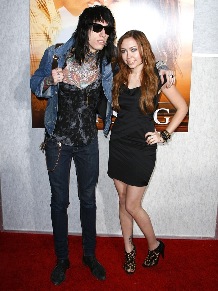 Brandi Cyrus poses with her younger brother Trace Cyrus at the Los Angeles premiere of The Last Song on March 25, 2010, at ArcLight Hollywood, turning heads in a ruched black mini dress and gold-studded peep-toe ankle boots that added edge to her red carpet style