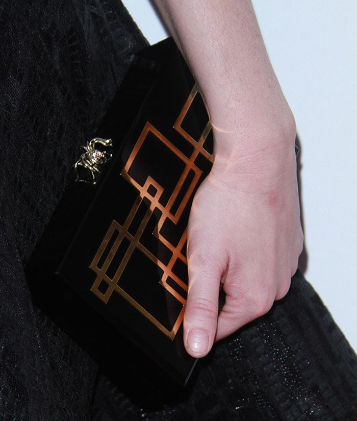 Christina Hendricks holds a Charlotte Olympia clutch with her unmanicured fingers