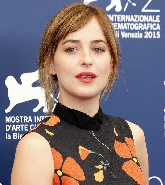 Dakota Johnson poses in front of a backdrop at the Venice Film Festival