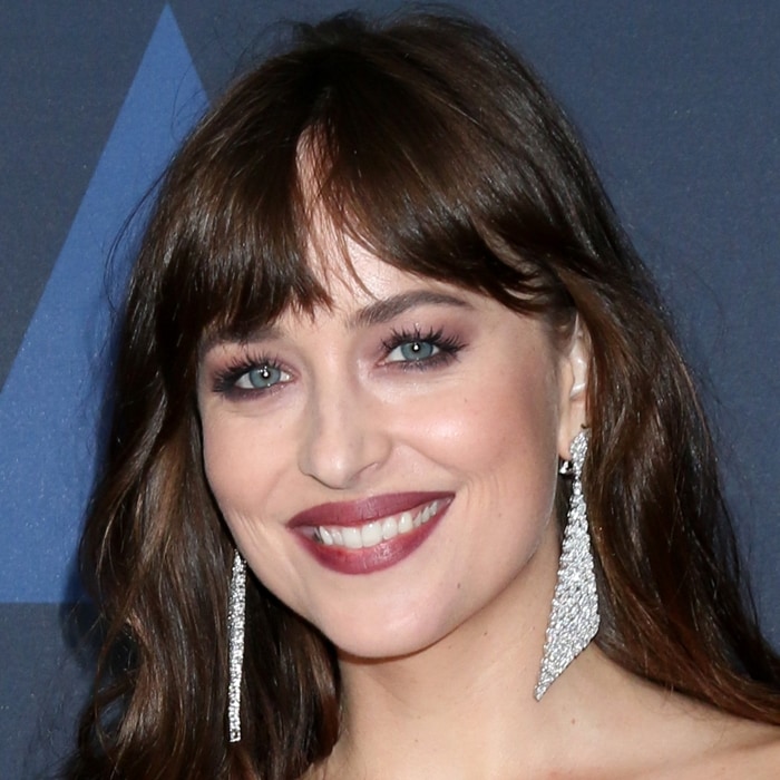Dakota Johnson flashes a radiant smile, revealing the once-famous gap between her front teeth, which became one of her most recognizable features early in her career