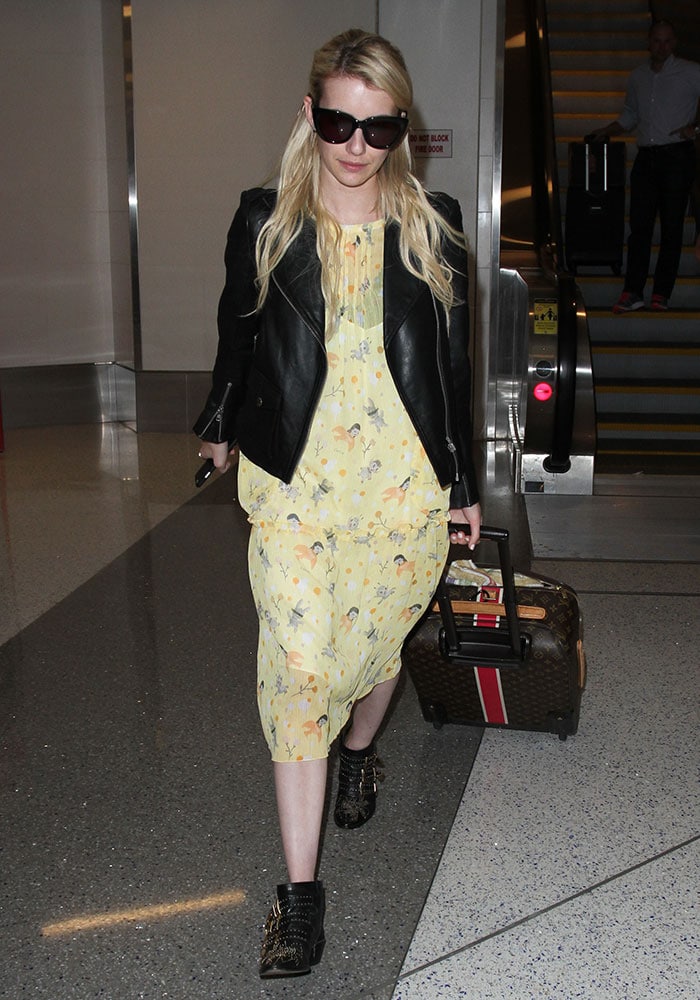 Emma Roberts arrives at Los Angeles International Airport on September 4, 2015, pairing a breezy yellow floral dress with a black leather jacket and Chloé’s iconic studded “Susanna” ankle boots