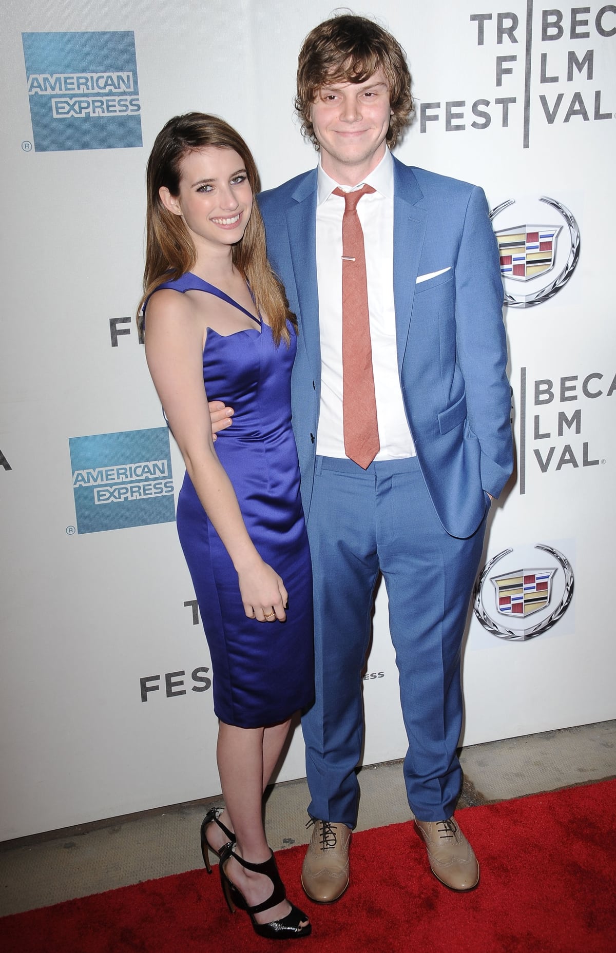 Evan Peters and Emma Roberts pose together at the Adult World premiere after party during the 2013 Tribeca Film Festival in New York City on April 18, 2013—Emma in a Cushnie Et Ochs dress with Walter Steiger sandals and a Jimmy Choo clutch, while Evan opted for a blue suit and tan lace-up shoes