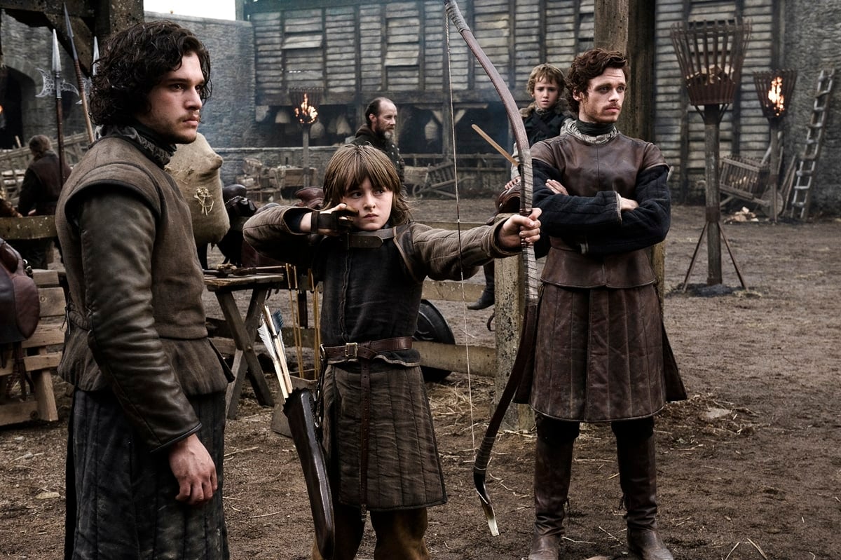 Young Bran Stark practices archery under the watchful eyes of Jon Snow and Robb Stark in this iconic early scene from Game of Thrones