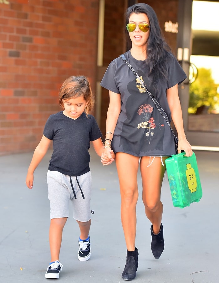 Kourtney Kardashian keeps it effortlessly cool in an oversized graphic tee and Saint Laurent boots while out with her son Mason in Calabasas on September 26, 2015