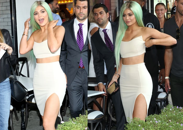 Kylie Jenner adjusts the crop top on her Zachary the Label set as she arrives at a lingerie store opening