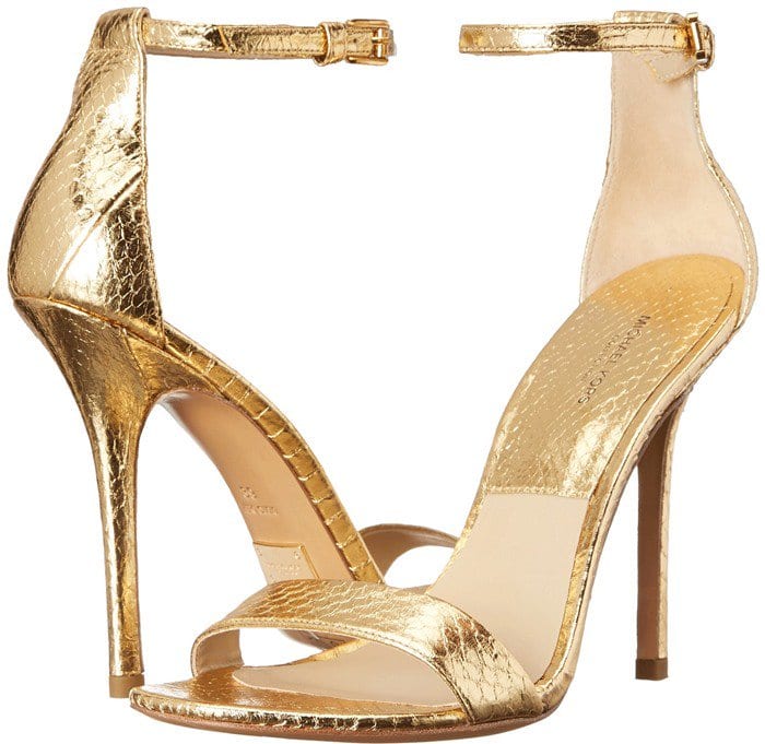 Michael Kors’ “Jacqueline” sandal shines in crackled metallic gold leather, featuring a slim ankle strap, minimalist toe band, and a leg-lengthening stiletto heel that embodies sleek, red-carpet-ready glamour