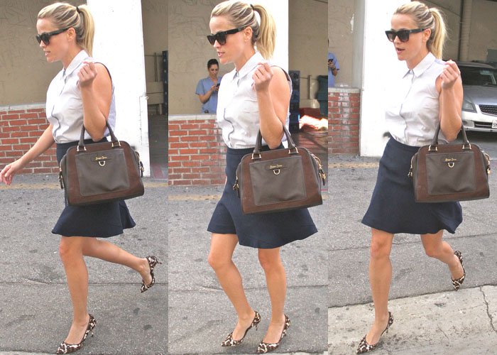 Reese Witherspoon runs errands in a collared top and a navy blue skirt, accentuating her look with animal print heels