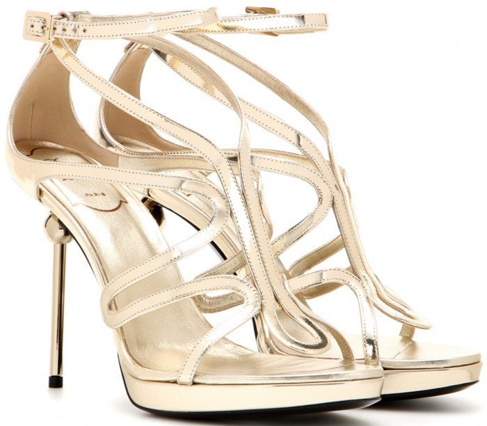 Roger Vivier “Ondulation” metallic gold leather sandals showcase the line’s signature undulating straps and sleek stiletto heel, creating a fluid, jewelry-like effect for evening wear