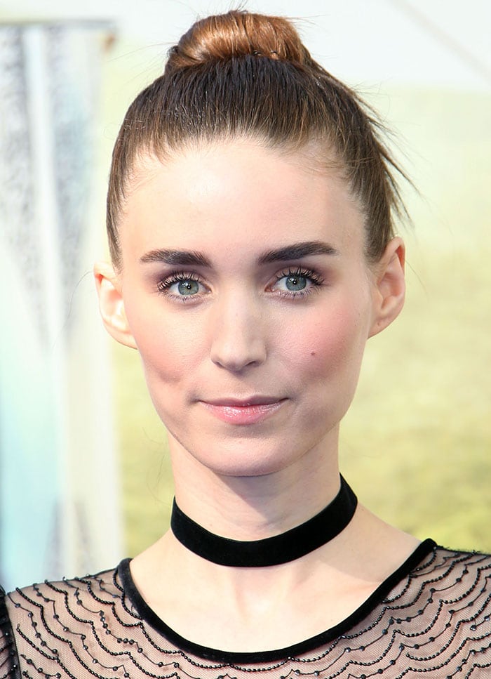 Rooney Mara finishes her London Pan premiere look with a sleek top knot and a black velvet choker, complementing the sheer detailing of her Givenchy dress